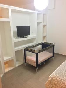 een kleine kamer met een tv en een plank bij B&B Stefyld in Paola