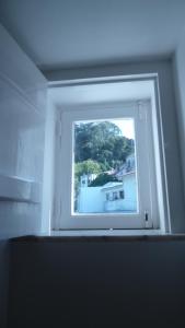 a window in a room with a view of a house at ribeira dos marinheiros amarelo in Sintra