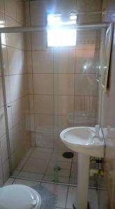 a bathroom with a shower with a sink and a toilet at Hotel Cadore in Bauru