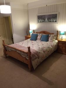 a bedroom with a large wooden bed with blue pillows at Church Farm in Gillingham