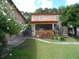 ein Haus mit einem Zaun und einem Garten mit Blumen in der Unterkunft Casa Ingleses in Viro