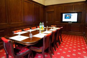 a conference room with a table and chairs and a television at Whiston Hall in Whiston
