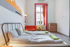a bedroom with a bed and a red chair at Pal's Mini Hostel in Budapest