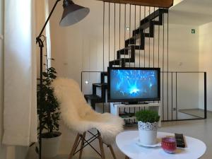 a living room with a tv and a white furry stool at Central Split rooms and apartments Paese in Split