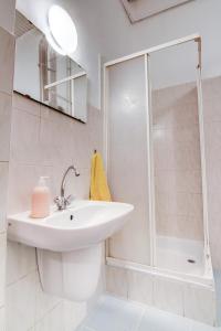 a white bathroom with a sink and a shower at Pal's Mini Hostel in Budapest