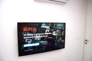 einen Flachbild-TV, der an einer Wand hängt in der Unterkunft Smart Tech Plaza Flat in Salamanca