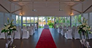 a banquet hall with white chairs and a red carpet at Mercure Townsville in Townsville