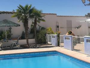 a swimming pool in front of a house at Finca Las Eras in Herencia