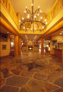 a large lobby with a chandelier and a fireplace at Snow Creek Lodge by Fernie Lodging Co in Fernie