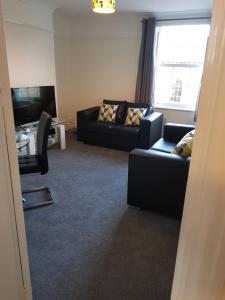 a living room with two couches and a television at Braganza House in Portsmouth