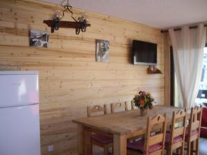 ラルプ・デュエズにあるChalet Amandineのキッチン(木製テーブル、冷蔵庫付)