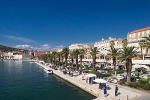 a group of people walking along a river with palm trees at Guesthouse Teta Palmina in Split