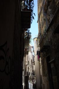 une ruelle étroite avec des bâtiments et une usine sur un balcon dans l'établissement L'Atelier Dei Quattro Canti, à Palerme