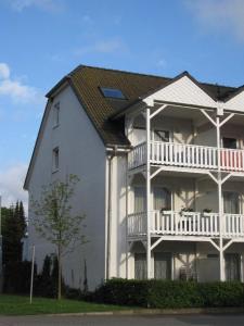 巴貝的住宿－Familie-und-Meer-2-Badezimmer-3-Schlafzimmer-Strandnah-im-Ostseebad-Baabe-Baabe，白色的大房子,设有白色阳台