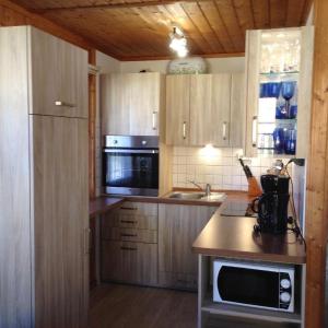 a kitchen with wooden cabinets and a counter top at Schwedenhaus-Seeblick-Useriner-See in Userin