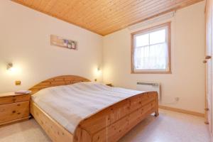 a bedroom with a wooden bed and a window at Haus-am-See in Userin