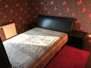 a bedroom with a bed with a red rug at Deluxe Home in Pécs