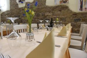 einen Tisch mit einem weißen Tischtuch und einer Blumenvase in der Unterkunft Il FEUDO in San Gimignano