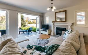 a living room with a couch and a fireplace at Island Time in Oneroa