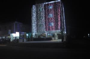 um edifício alto com luzes acesas à noite em Vettoor Nanas Inn em Ettumānūr