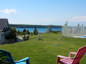 two chairs sitting in a yard with a soccer goal at Waterview On The Bay in Wiarton