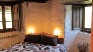 a bedroom with a bed with two candles on it at Casa do Solpor in La Teijeira