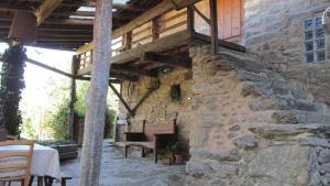 a stone building with a wooden deck on a patio at Casa do Solpor in La Teijeira