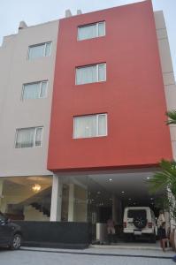 ein rotes Gebäude mit einem davor geparkt in der Unterkunft Vettoor Nanas Inn in Ettumānūr