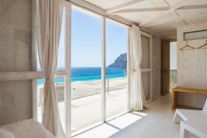 a bedroom with a view of the beach at Aquiles Eco Hotel in São Pedro