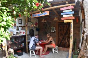 dos personas sentadas en una mesa fuera de una tienda en Viejamar B&B en Puerto López
