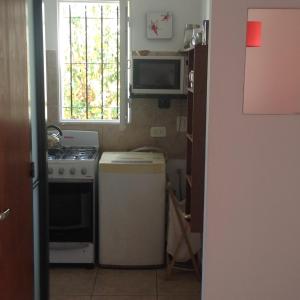 a small kitchen with a stove and a window at La Casa Roja Arroyito Rio in Rosario