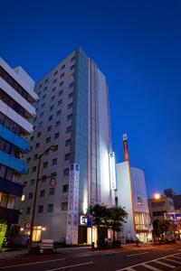 
a tall building with a clock on the side of it at S Peria Hotel Nagasaki in Nagasaki
