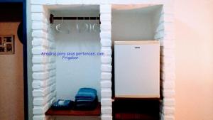 um quarto com um frigorífico e uma parede branca em Pouso Jambo Rosa em Valença