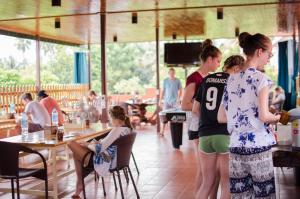 a group of people standing around in a restaurant at Vongprachan Backpackers Hostel in Luang Prabang