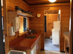 a kitchen in a log cabin with a sink and refrigerator at Dakune Chalet in Ohakune