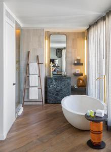 baño con bañera blanca grande y lavamanos en MADE Hotel, en Nueva York