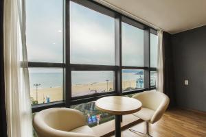 釜山にあるMS ホテル ヘウンデのビーチを望む大きな窓が備わる客室です。