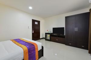 a bedroom with a bed and a flat screen tv at Studio Residence Sukhumvit 71 in Bangkok