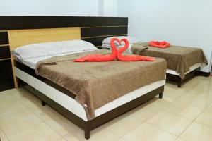zwei Betten mit roten gefüllten Tieren darüber in der Unterkunft Global 88 Apartelle in Cebu City