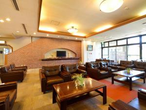 a lobby with leather furniture and a brick wall at Hotel Wellness Notoji in Hakui