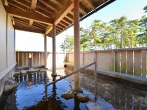 a pool of water in a house with a roof at Hotel Wellness Notoji in Hakui