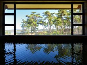 a window with a view of trees and water at Hotel Wellness Notoji in Hakui