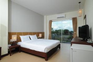 Mawin Hotel في شيانغ ماي: غرفة نوم بسرير ونافذة كبيرة