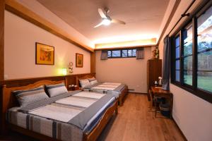 a bedroom with two beds and a television in it at Amrita Green Retreat in Chaozhou