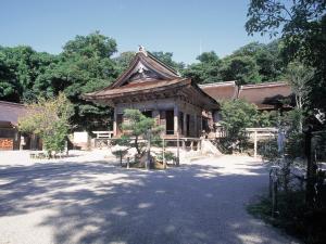 a building with a roof with a tree in front of it at Hotel Wellness Notoji in Hakui
