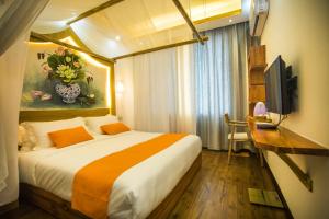 a bedroom with a bed and a desk and a television at Home of heart Inn in Zhangjiajie