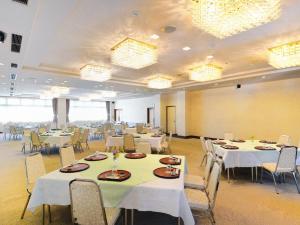 a banquet hall with white tables and chairs at Hotel Wellness Notoji in Hakui +16 photos