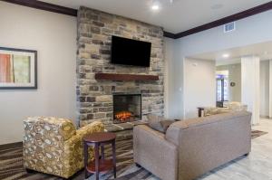 a living room with two couches and a fireplace at Cobblestone Inn & Suites - Guernsey in Guernsey