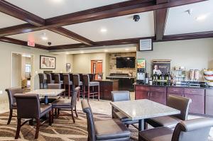 a restaurant with tables and chairs and a bar at Cobblestone Inn & Suites - Guernsey in Guernsey