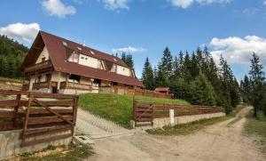 a house on top of a hill with a fence at Cabana Free Land in Comandău